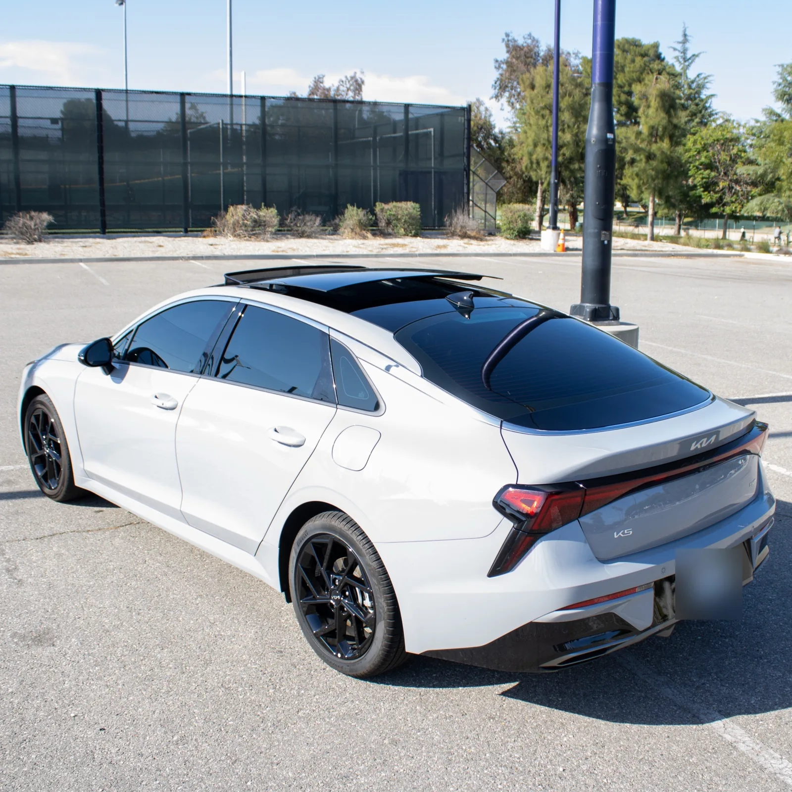 Grey Kia K5, rear with panoramic roof